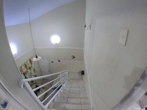 eine Treppe mit weißen Wänden und einer weißen Treppe in der Unterkunft Sobrado Aconchegante - Praia Peruíbe in Peruíbe