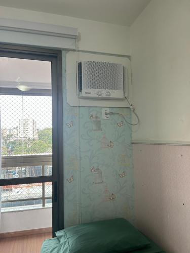 a bedroom with a heater on the wall next to a window at Aconchegante apt com vista para o mar de Camburi in Vitória