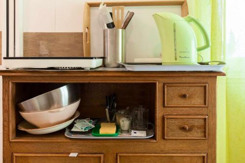 a wooden cabinet with bowls and utensils on it at Studio cosy à Plouédern, 18 m² avec jardin et parking in Plouédern
