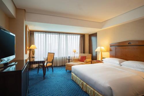 Habitación de hotel con cama grande y TV en Renaissance Tianjin TEDA Convention Centre Hotel, en Binhai