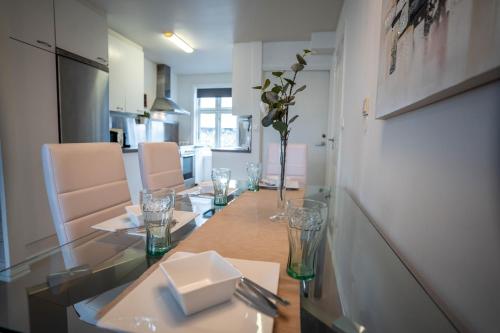 een eetkamer met een glazen tafel en stoelen bij Unique 3bed Rooms - Generous Terrace - Central Stavanger in Stavanger