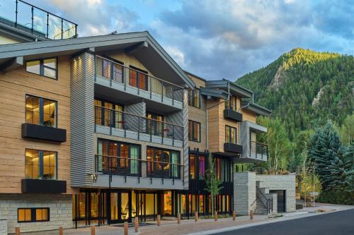 un edificio de apartamentos con una montaña en el fondo en W Aspen en Aspen