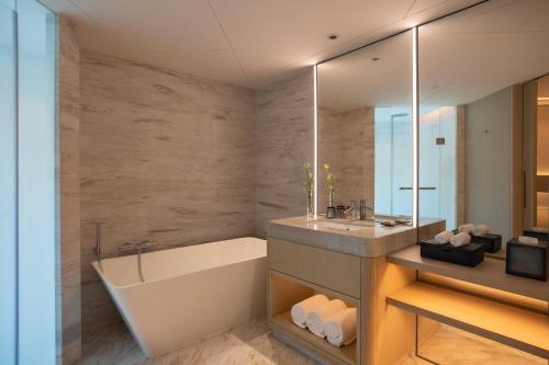 a bathroom with a tub and a sink and a mirror at Renaissance Shenzhen Luohu Hotel in Shenzhen