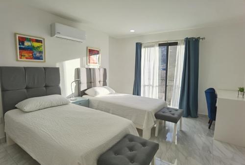 a hotel room with two beds and a window at Morgan Hotel Boutique & Residences, Los Cabos in Cabo San Lucas