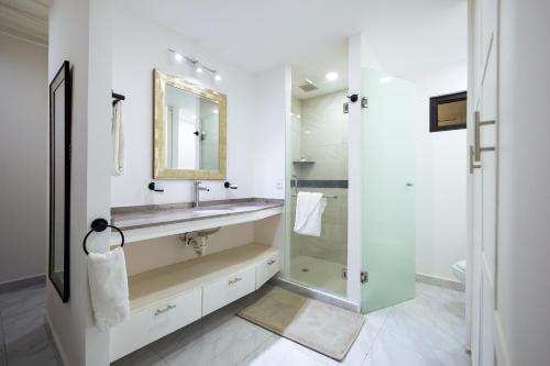 a bathroom with a sink and a mirror at Morgan Hotel Boutique & Residences, Los Cabos in Cabo San Lucas