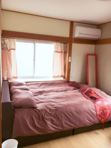 a large bed in a room with a window at 免费Wi-Fi 地铁站5分钟 10分种步行稲荷大社 坐地铁10分到京都站 交通便利 餐厅便利店超市俱全 in Kyoto
