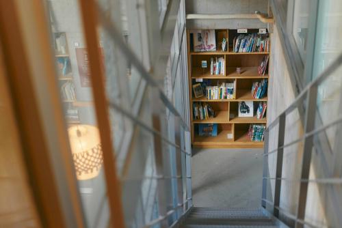 uma estante cheia de livros numa biblioteca em Common de - Hostel & Bar em Fukuoka