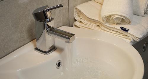 a bathroom sink with a faucet and a towel at Slaney Suites in Enniscorthy