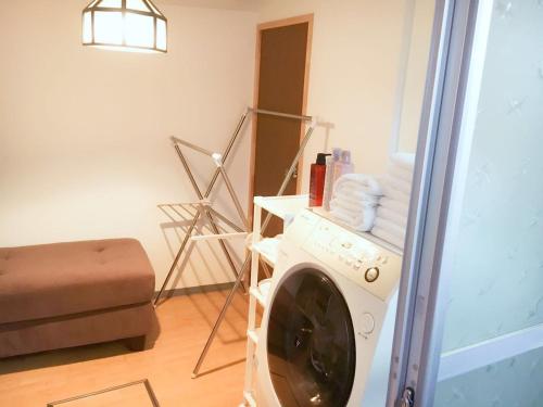 a living room with a washing machine in a room at 免费Wi-Fi 地铁站5分钟 10分种步行稲荷大社 坐地铁10分到京都站 交通便利 餐厅便利店超市俱全 in Kyoto
