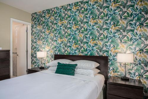 a bedroom with a large bed with a tropical wallpaper at The Local - St. Augustine in St. Augustine