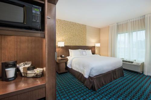 a hotel room with a bed and a flat screen tv at Fairfield Inn & Suites by Marriott Dayton in Dayton