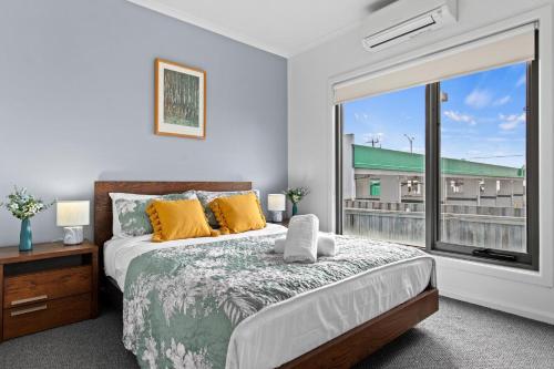 ein Schlafzimmer mit einem Bett und einem großen Fenster in der Unterkunft Bliss on the Bay - Full House in Rye