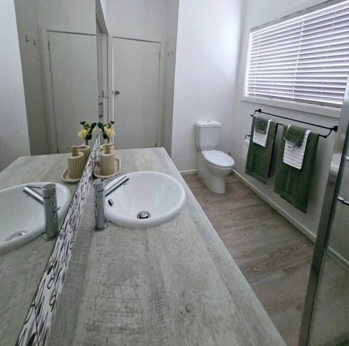 a bathroom with a sink and a toilet at San Remo Coastal Apartment in San Remo