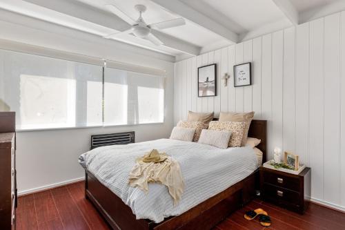 a bedroom with a bed and a ceiling fan at Rosebud Hideaway - Cute Contemporary by the Beach in Rosebud