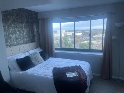 um quarto com uma cama e uma grande janela em ENTIRE HOME At Cherry Hill Towers- Chic Retreat With Queen Bed and Coffee Bar em Cherry Hill