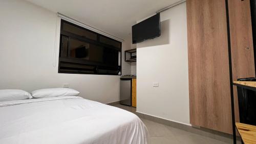 a bedroom with a bed and a flat screen tv at Casa hotel Los Laureles in Medellín