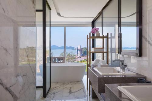 a bathroom with a tub and a large window at Xuzhou Marriott Hotel Lakeview in Xuzhou