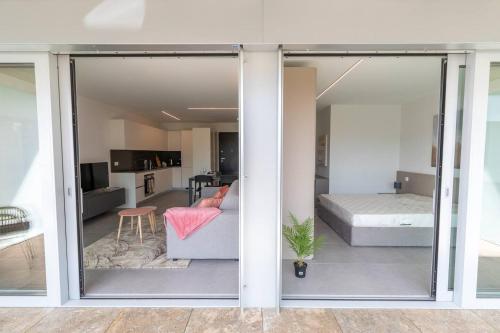 sala de estar con una puerta corredera de cristal que conduce a un dormitorio en Argento Spectacular and Modern 5 for 4 guests -By EasyLife Swiss, en Bellinzona