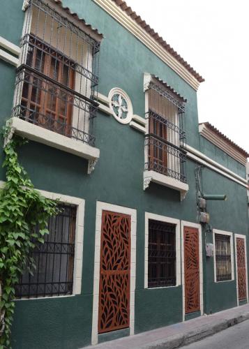 een groen gebouw met ramen en een klok erop bij Casa Cecilia Santa Marta in Santa Marta