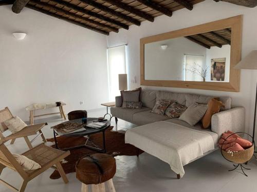 ein Wohnzimmer mit einem Sofa und einem Spiegel in der Unterkunft Fonte Freixo, em Borba, Alentejo in Borba