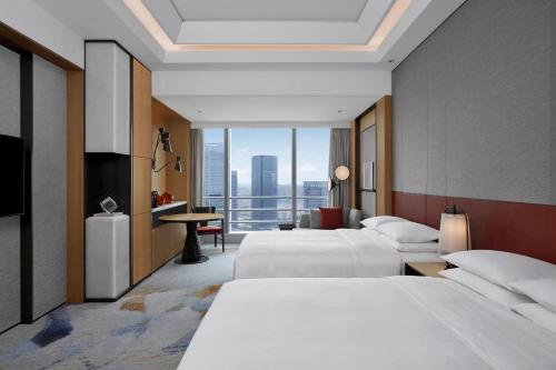 a hotel room with two beds and a balcony at Sheraton Guangzhou Panyu in Guangzhou