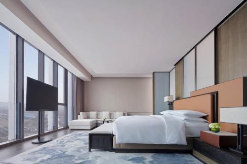 a hotel room with a bed and a tv at Liyang Marriott Hotel in Liyang