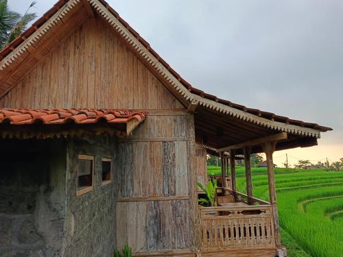 a small wooden house in front of a rice field at D'Ume Bendoel Homestay in Jatiluwih