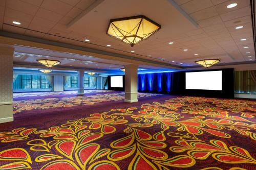 a ballroom with a large carpeted room with a stage at Pittsburgh Marriott City Center in Pittsburgh