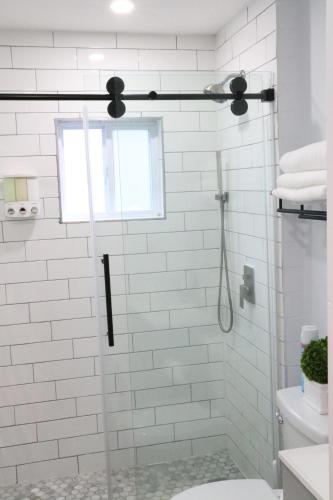 uma casa de banho com um chuveiro, um WC e uma janela. em 4 bedroom short term rental furnished Apt em Schenectady