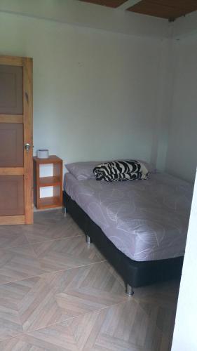um quarto com uma cama e piso em madeira em Hospedaje Naturaleza Viva em São Rafael