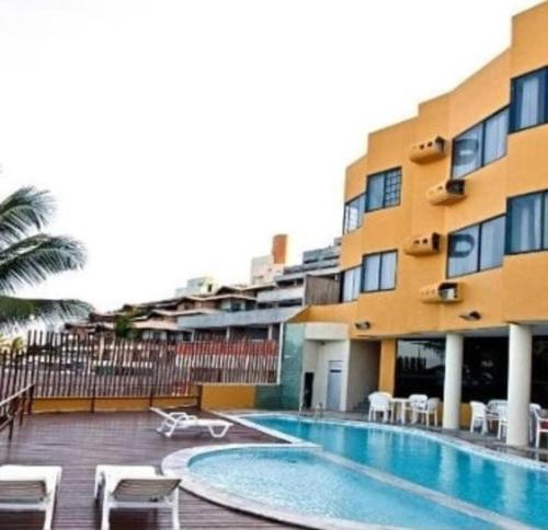 un edificio con piscina accanto a un edificio di Atlântico Flat - Pé na Areia em Ponta Negra -114 a Natal