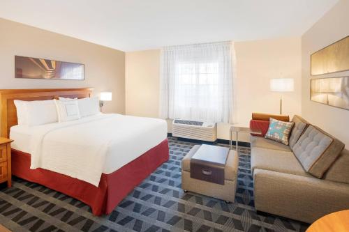 ベントンビルにあるTownePlace Suites by Marriott Bentonville Rogersのベッドとソファ付きのホテルルーム
