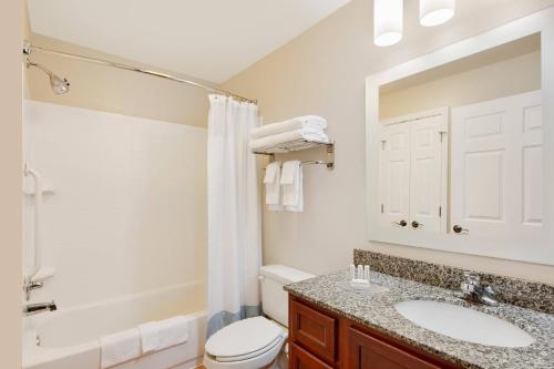 La salle de bains est pourvue d'un lavabo, de toilettes et d'un miroir. dans l'établissement TownePlace Suites by Marriott Bentonville Rogers, à Bentonville