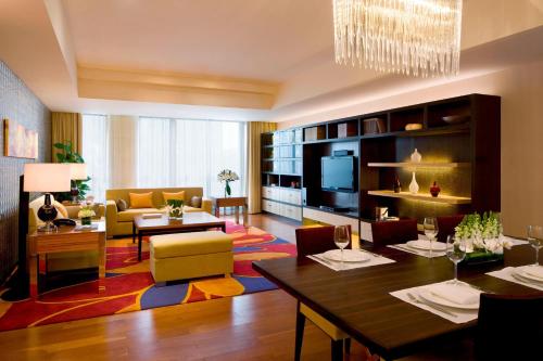 a living room with a table and a dining room at The Sandalwood Beijing Marriott Executive Apartments in Beijing