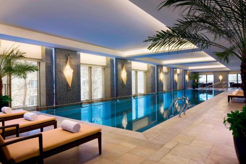 a large swimming pool in a building with a hotel at The Sandalwood Beijing Marriott Executive Apartments in Beijing