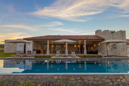 eine Villa mit einem Pool vor einem Gebäude in der Unterkunft Hotel Vinícola Parvada by Lumina in Parras de la Fuente