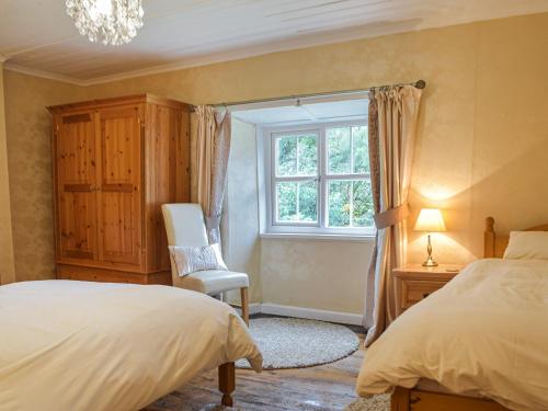 Henllan AmgoedにあるParke Cottageのベッドルーム1室(ベッド1台、窓、椅子付)