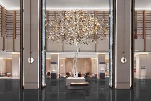 a large chandelier in a hotel lobby with a tree at Courtyard Taiyuan in Taiyuan