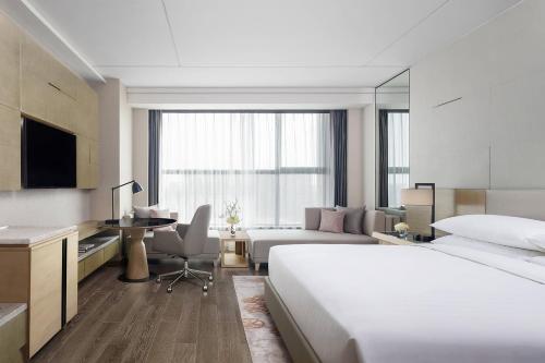 - une chambre d'hôtel avec un lit et un bureau dans l'établissement Shanghai Marriott Hotel Kangqiao, à Shanghai