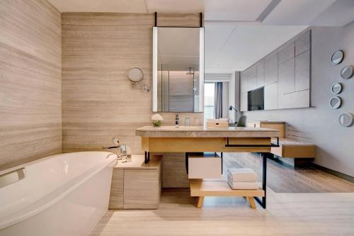 a bathroom with a tub and a sink and a bath tub at Shanghai Marriott Hotel Kangqiao in Shanghai