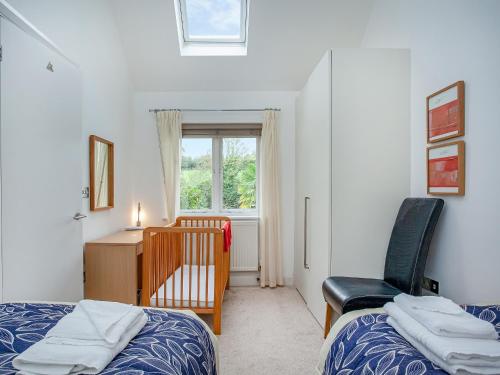 a bedroom with two beds and a chair and a desk at Villa Gallery- 27073 in Perranwell