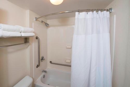 La salle de bains est pourvue d'une douche et d'un rideau de douche blanc. dans l'établissement SpringHill Suites by Marriott Atlanta Alpharetta, à Alpharetta