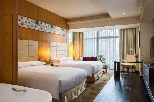 a hotel room with two beds and a desk at Renaissance Shanghai Putuo Hotel in Shanghai