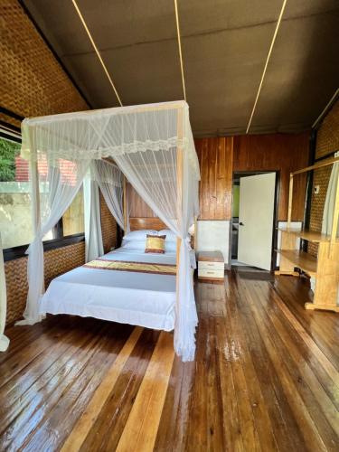 a bedroom with a bed with a canopy at Ursula Beach Resort in El Nido