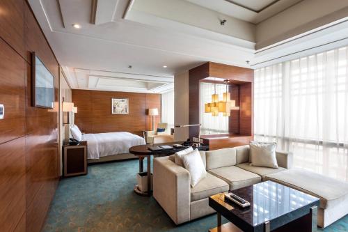 鄭州市にあるJW Marriott Hotel Zhengzhouのソファとベッド付きのホテルルーム