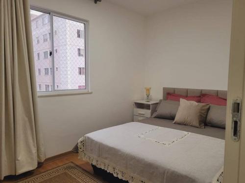 a white bedroom with a bed and a window at Meu@Apê JF911 *Self-check-in*Elevador *Vaga grátis in Juiz de Fora
