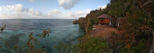 a view of the ocean with a house on the shore at Pombero lodge in Tano