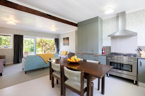 a kitchen and living room with a table and a couch at Cliffscapes in Punakaiki