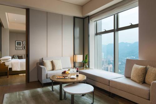 a living room with a couch and a table at Chongqing Marriott Hotel in Chongqing