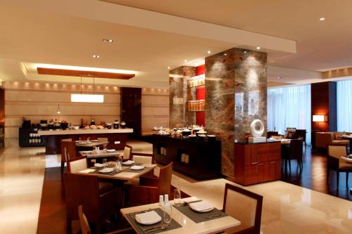 a restaurant with tables and chairs and a bar at Courtyard by Marriott Shanghai Jiading in Jiading